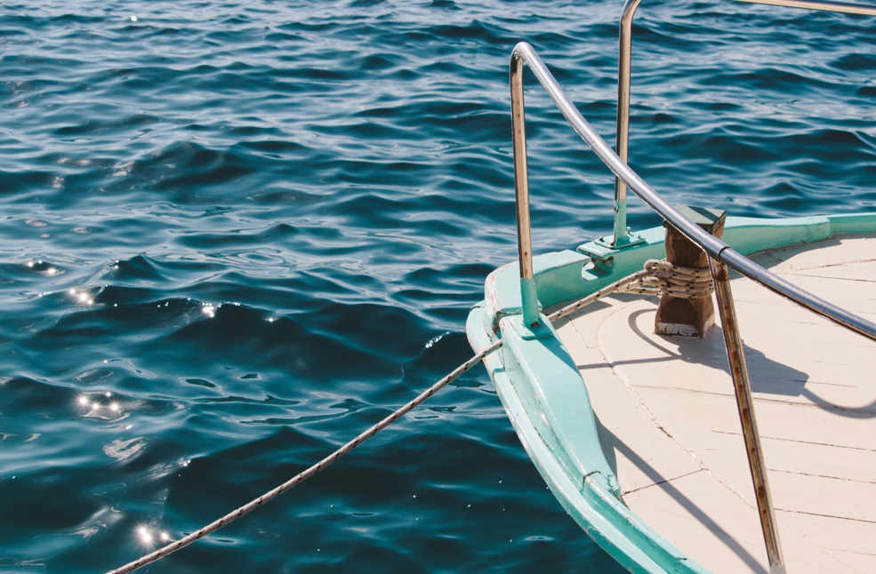 The edge of a boat with water in the background