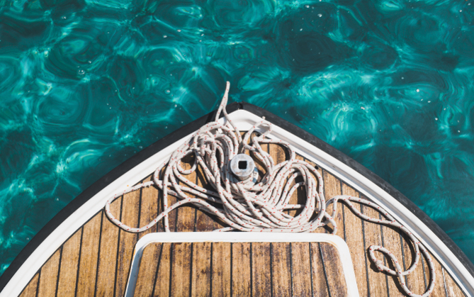 A shot of the front of a boat with ropes on the deck